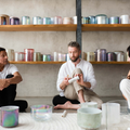 Sound healing training session in progress, featuring participants practicing with crystal singing bowls and receiving hands-on guidance to master sound bath techniques and earn certification.