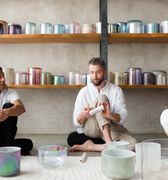 Sound healing training session in progress, featuring participants practicing with crystal singing bowls and receiving hands-on guidance to master sound bath techniques and earn certification.