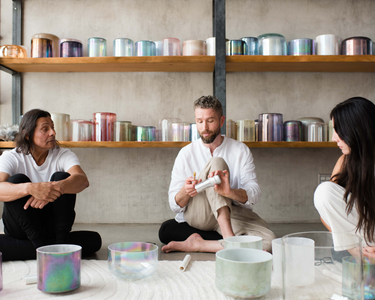 Sound healing training session in progress, featuring participants practicing with crystal singing bowls and receiving hands-on guidance to master sound bath techniques and earn certification.