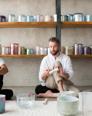 Sound healing training session in progress, featuring participants practicing with crystal singing bowls and receiving hands-on guidance to master sound bath techniques and earn certification.