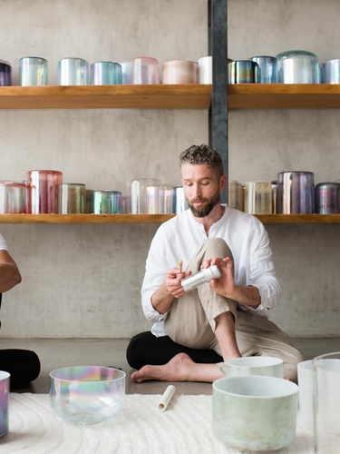 Sound healing training session in progress, featuring participants practicing with crystal singing bowls and receiving hands-on guidance to master sound bath techniques and earn certification.